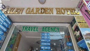 The exterior of the Allen Garden Hotel with a prominent sign for the travel agency and a list of tour packages. - Ailen Hotel (Ho Chi Minh City)