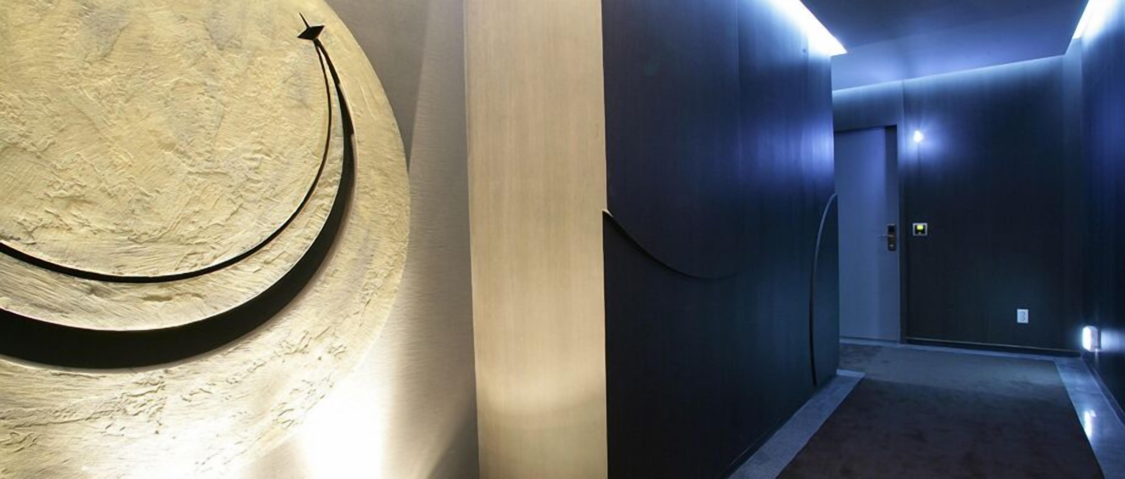 A hallway with a curved wall feature and a door at the end.