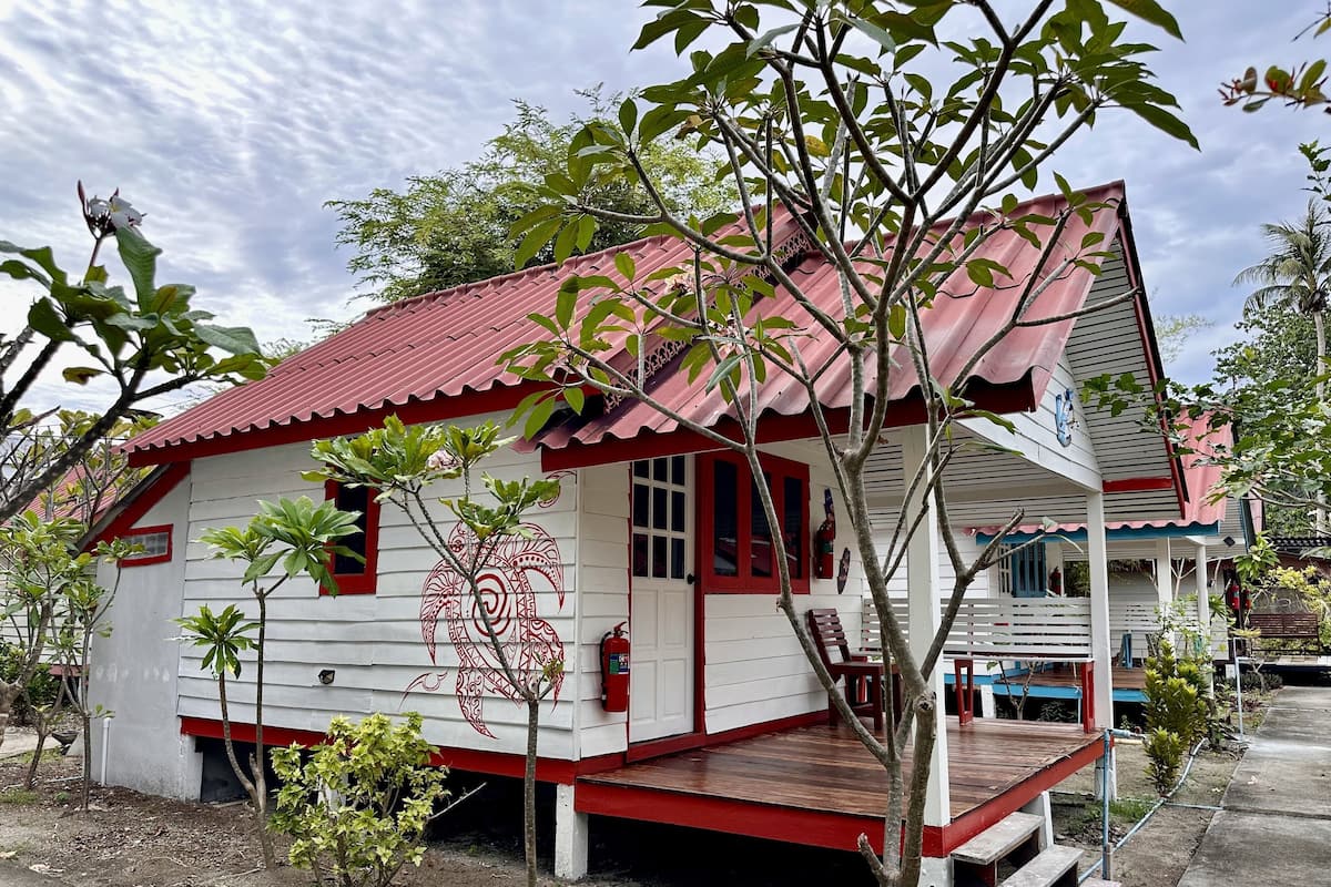 Un edificio blanco con techo rojo y un diseño decorativo en la pared.