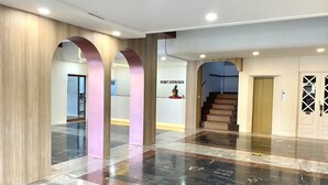 Eine geräumige Lobby mit Marmorboden, Holzvertäfelung und einer Rezeption.