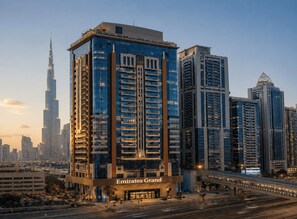 A high-rise building with a prominent sign reading 'Emirates Grand.' - Emirates Grand Hotel (Dubai)