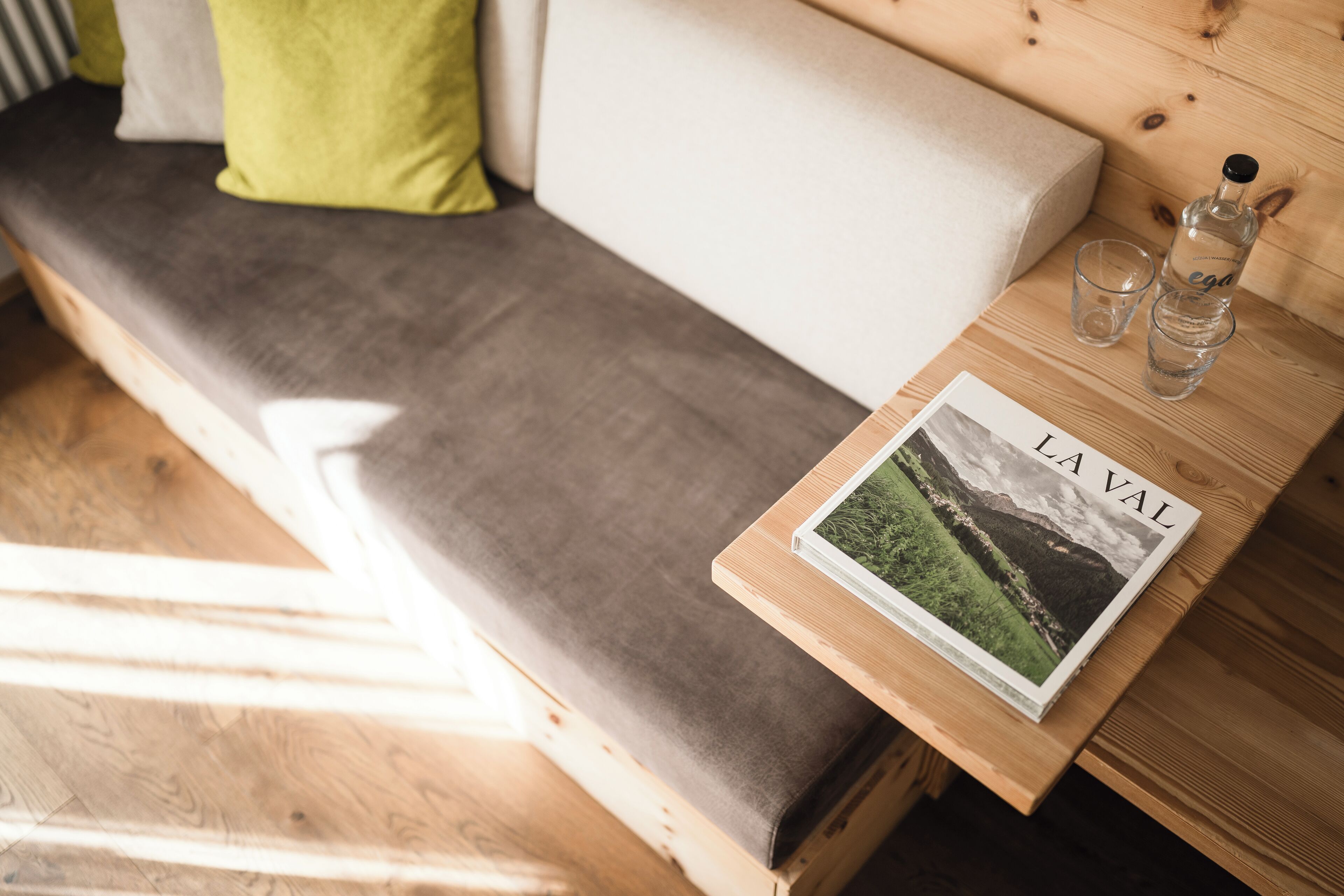 Ein Holztisch mit einer Zeitschrift mit dem Titel 'LAVAL' und zwei Gläsern Wasser.