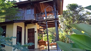 Una casa de madera con balcón, escalera y puerta.