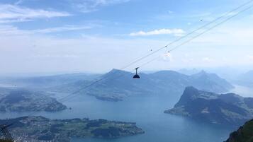 A cable car system with a mountainous landscape and a body of water in the background.
