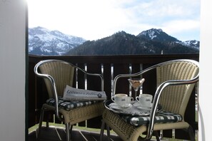 A balcony with wicker chairs, a tray with cups and a glass, and a newspaper. - Hotel Hammer (Schwarzenberg)