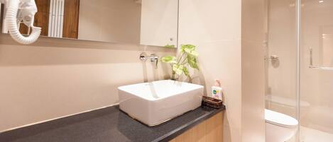 A modern bathroom with a rectangular sink, a glass shower enclosure, and a mirror above the sink.
