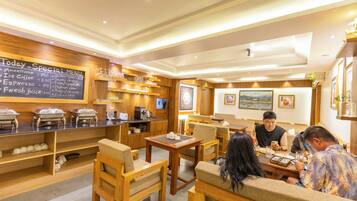 A restaurant with wooden furniture, a chalkboard menu, and various food and drink dispensers.