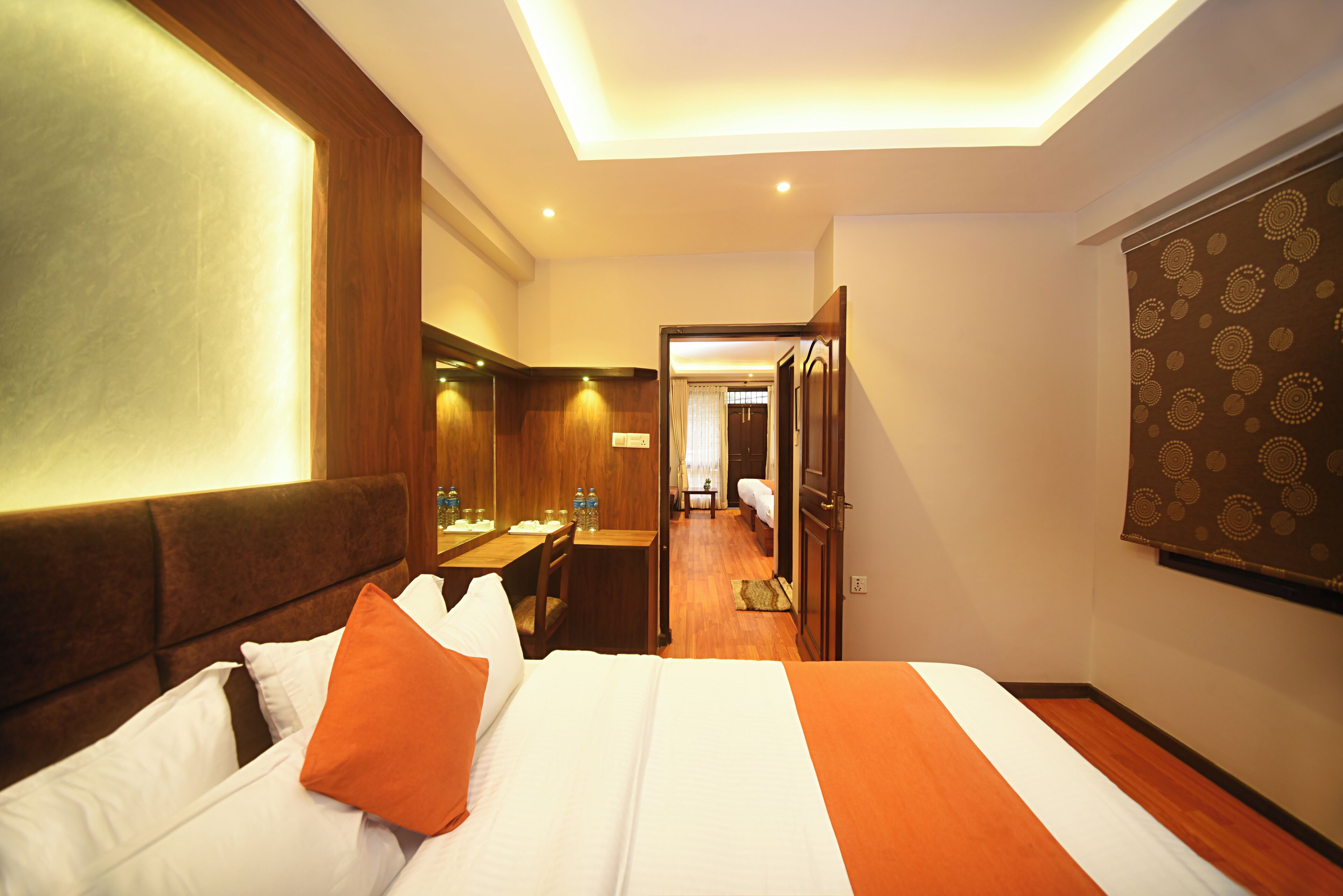 Una habitación de hotel con cama, escritorio y espejo.