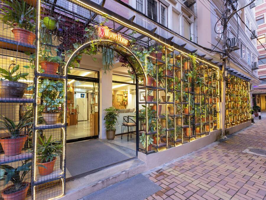 A storefront with a sign that reads 'I ♥ Mie's Home' and a display of potted plants.