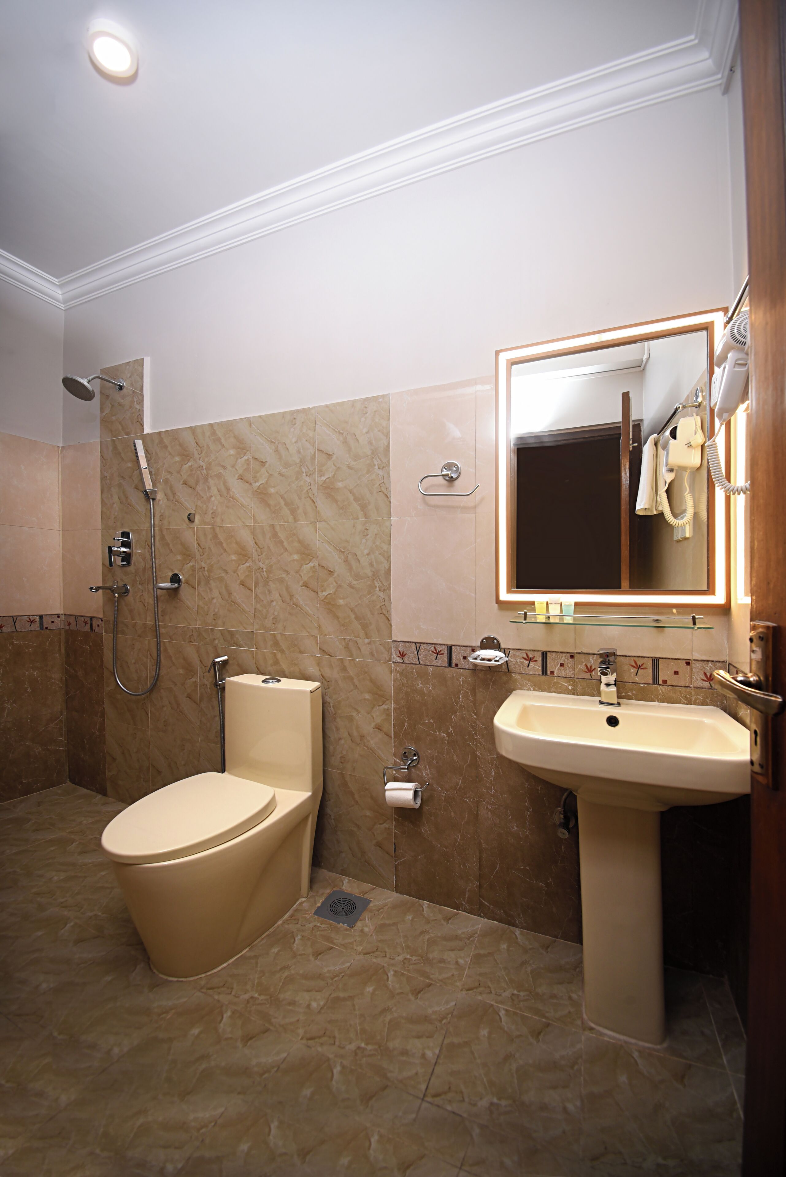 Une salle de bain avec des toilettes, un lavabo et une douche.