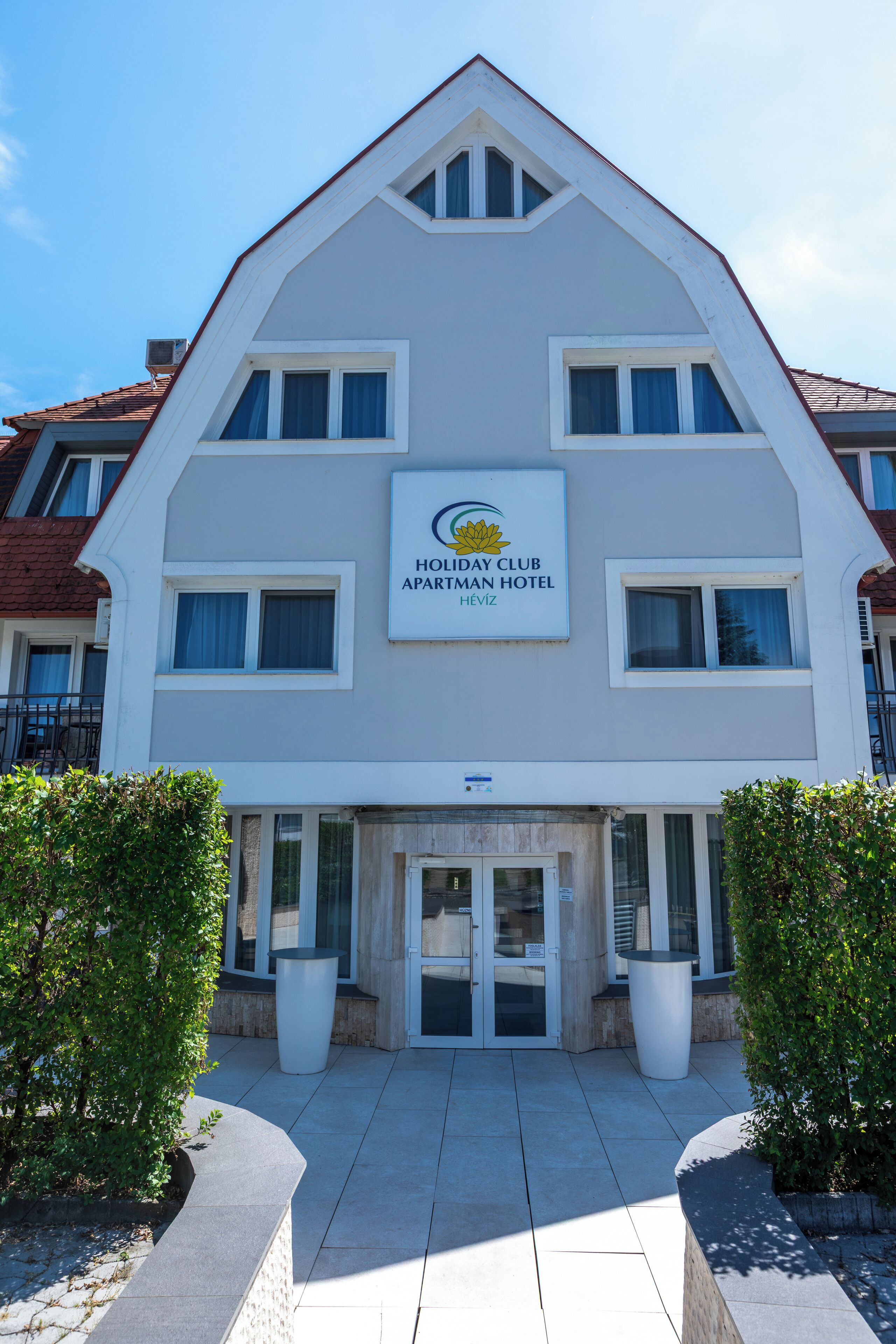 A multi-story building with a sign for 'Holiday Club Apatran Hotel.'