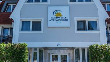 A multi-story building with a sign for 'Holiday Club Apatran Hotel.'