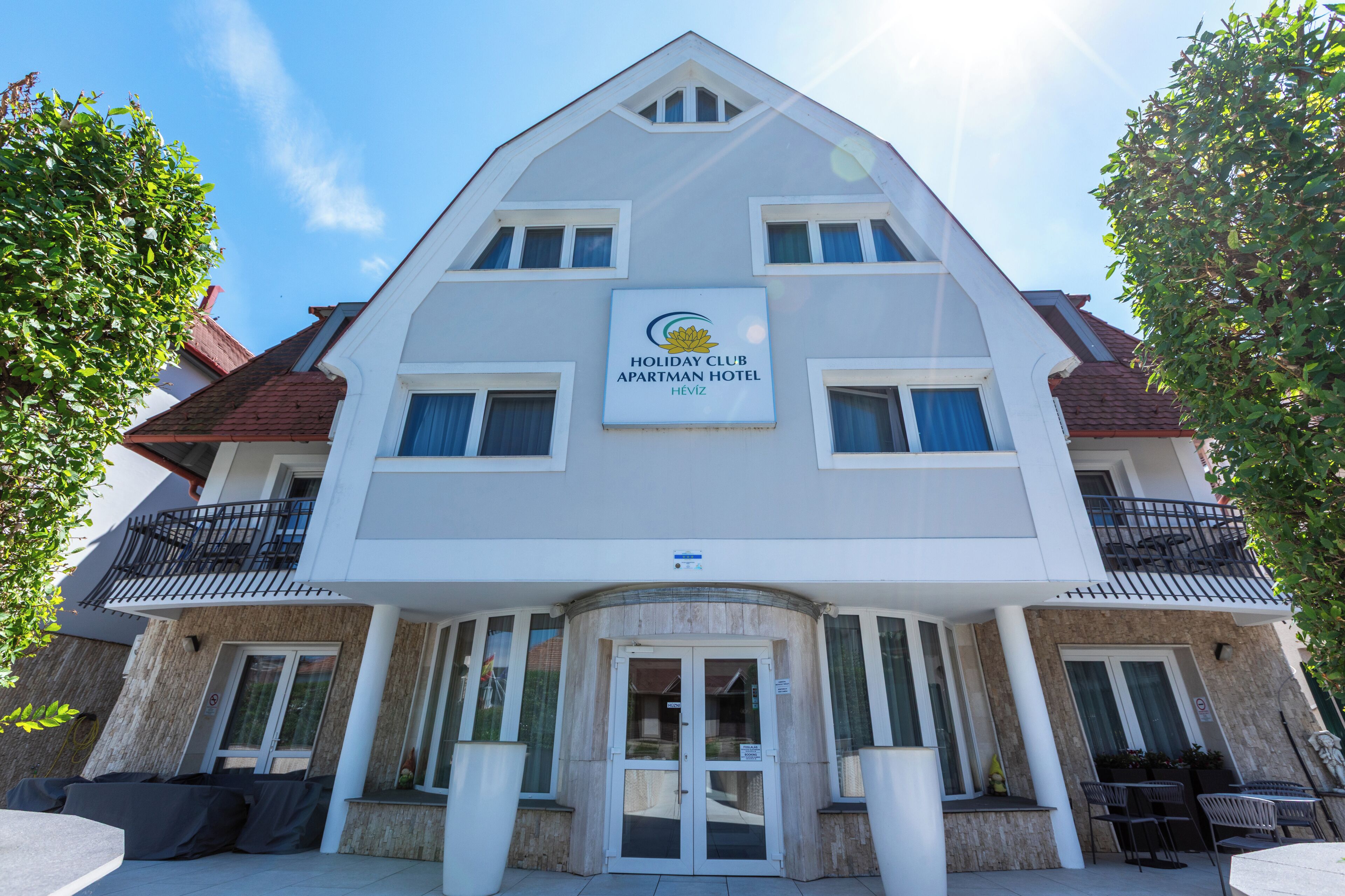 A multi-story building with a sign reading 'Holiday Club Apartment Hotel.'
