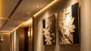 A hotel hallway with a carpeted floor, a wall-mounted light fixture, and a door. - The Cloud Hotel Kaohsiung (Kaohsiung)