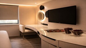 A modern room with a curved white desk, a flat-screen TV, a round mirror, and a window with a view. - The Cloud Hotel Kaohsiung (Kaohsiung)