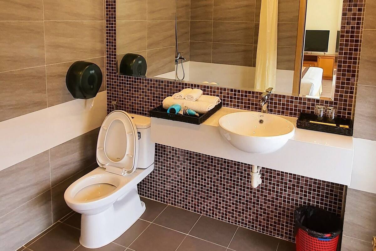 deluxe room | bathroom | shower, hair dryer, slippers, towels