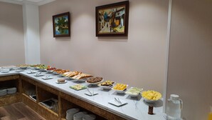 Un buffet proposant une variété de plats et un distributeur d’eau.