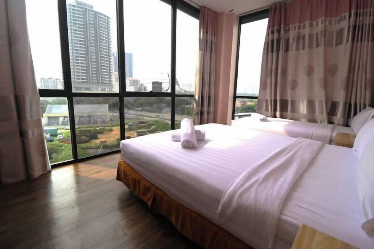 A hotel room with a large window, a bed with white linens, and a view of a cityscape.