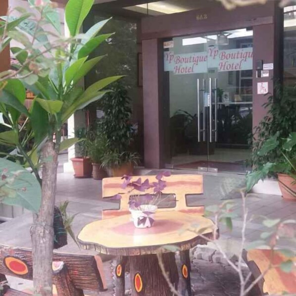 A wooden table with a sign in front of a building labeled 'Boutique Hotel'. - YP Boutique Hotel, Paradigm Mall Petaling Jaya (Petaling Jaya)