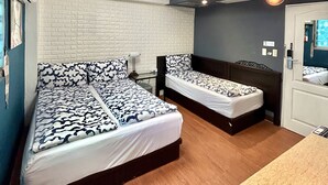 A room with two beds, a table, and a ceiling with recessed lighting. - Ximen Triple Tiger Hostel (Taipei)