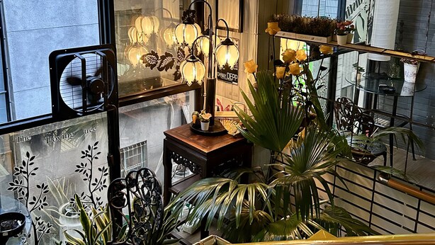 A modern interior with a large decorative light fixture, a staircase, and various potted plants. - Ximen Triple Tiger Hostel (Taipei)