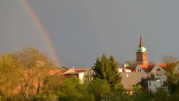 Eine Kirche mit einem hohen Kirchturm und einem Regenbogen im Hintergrund.