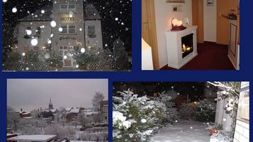 Un hotel con un letrero visible, una chimenea y un entorno cubierto de nieve.