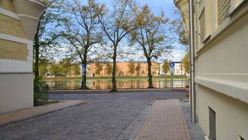 A paved pathway with trees and a body of water in the background.