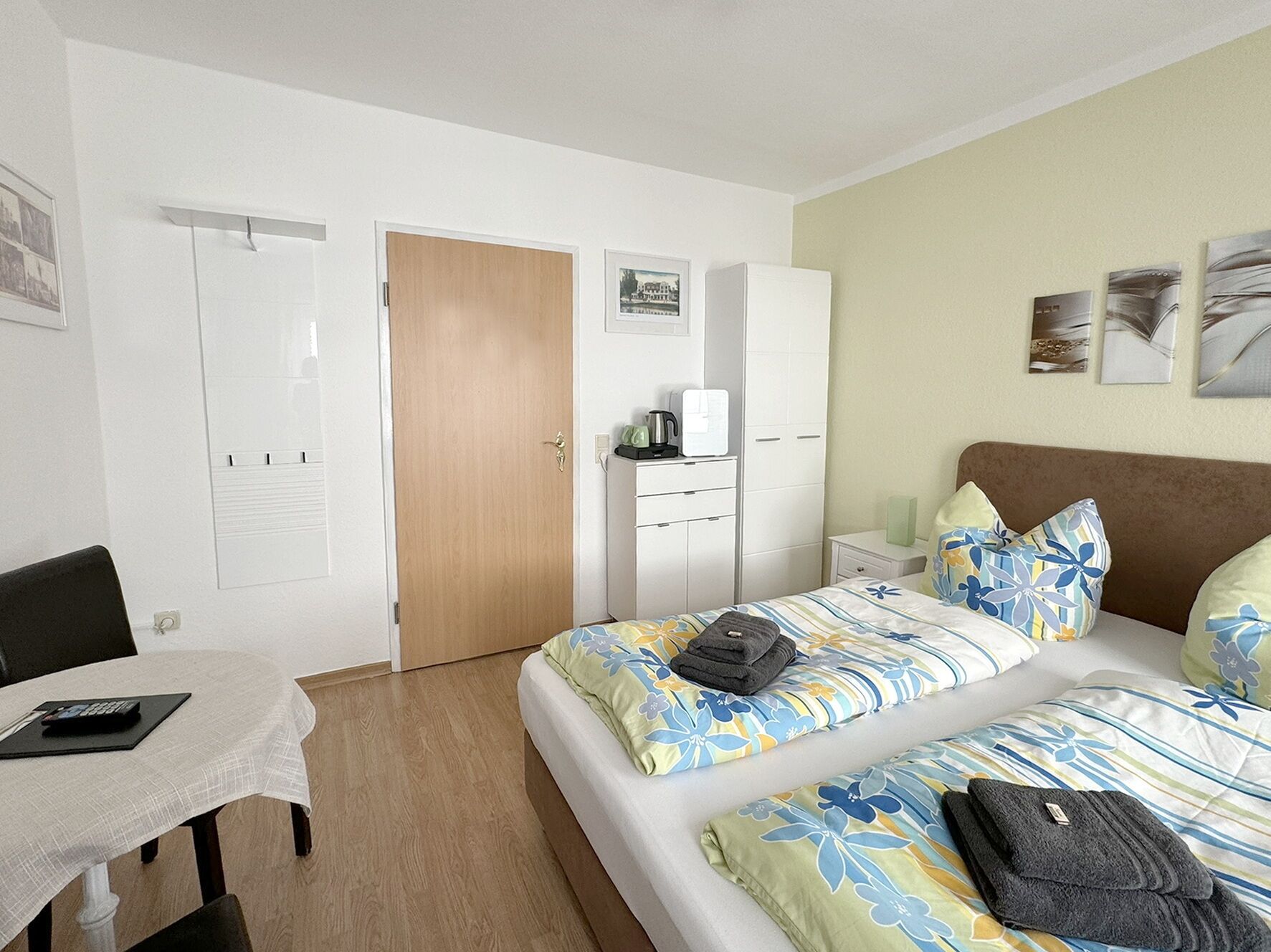 Habitació d'hotel amb dos llits, un escriptori, un armari i una cafetera.
