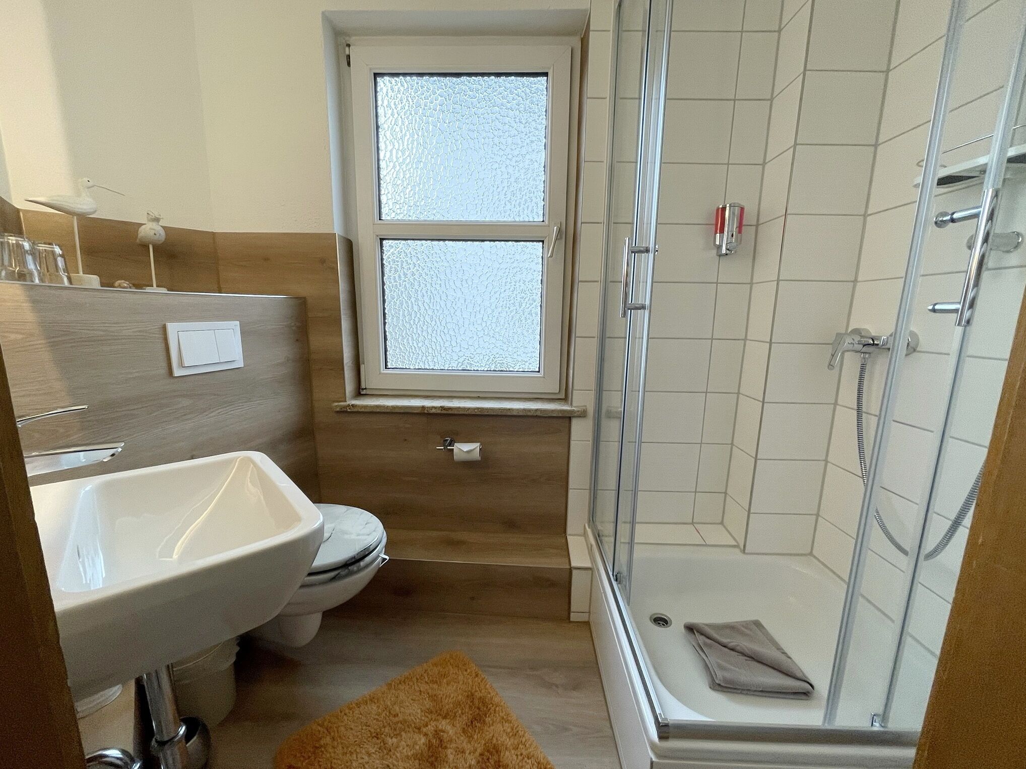 Un baño con inodoro, lavamanos y ducha.
