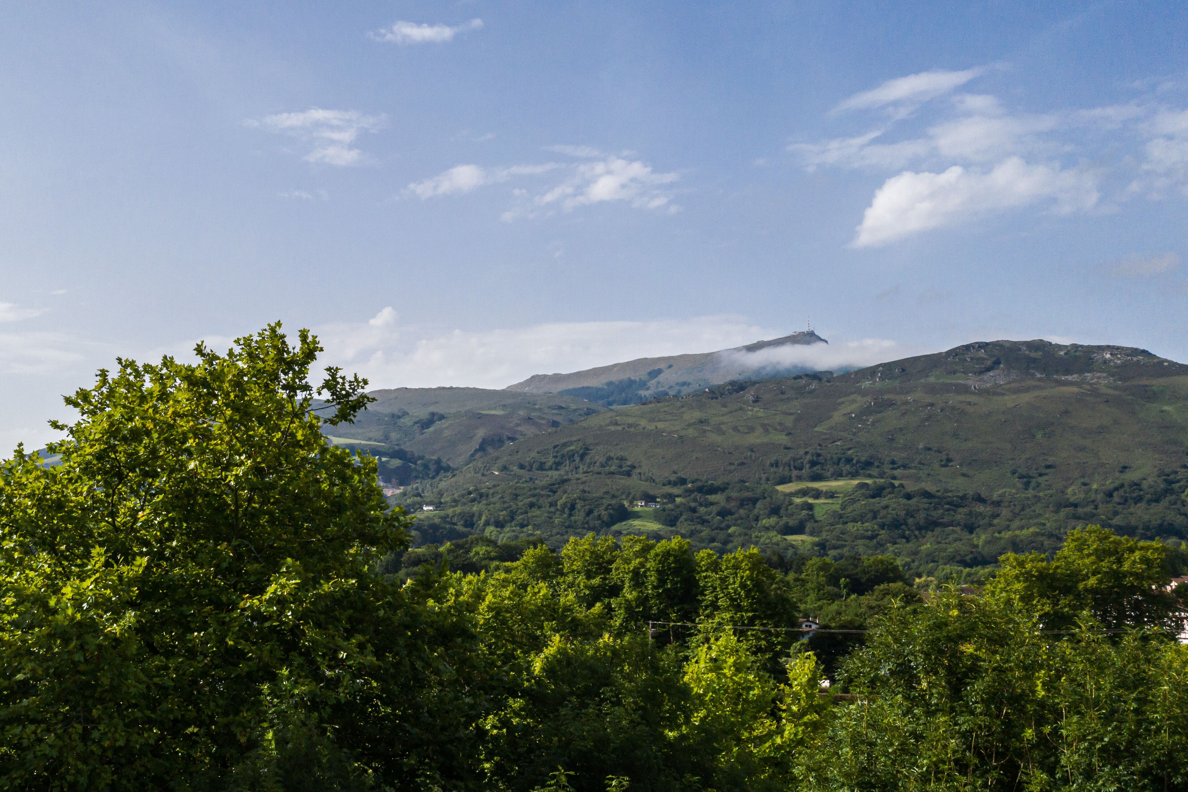 A mountainous landscape with lush greenery and a clear sky.