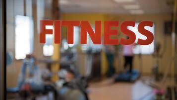 Ein verschwommener Innenraum eines Fitnessstudios, wobei das Wort 'FITNESS' gut sichtbar ist.