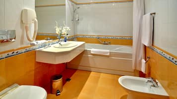 Un baño con inodoro, lavamanos, bañera y ducha.