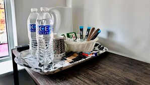 A tray with two water bottles, a mug, and a basket containing pens and tissues. - Trivelles Liverpool (Liverpool)