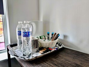 A tray with two water bottles, a mug, and a basket containing pens and tissues. - Trivelles Liverpool (Liverpool)