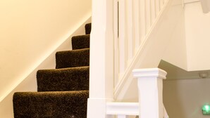 Eine Treppe mit Teppichstufen und weißen Geländern.