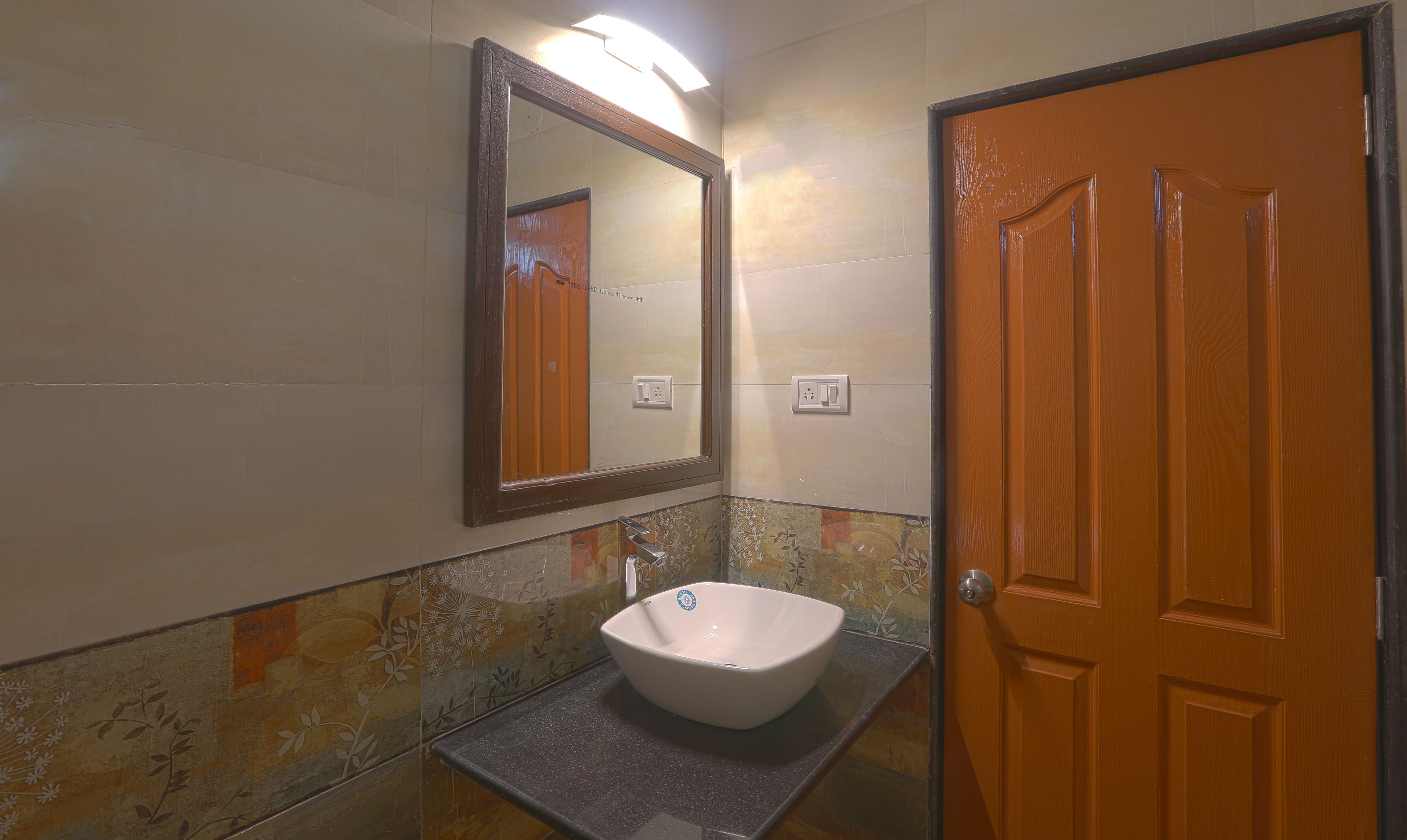 A bathroom with a white sink, a mirror, and a wooden door.