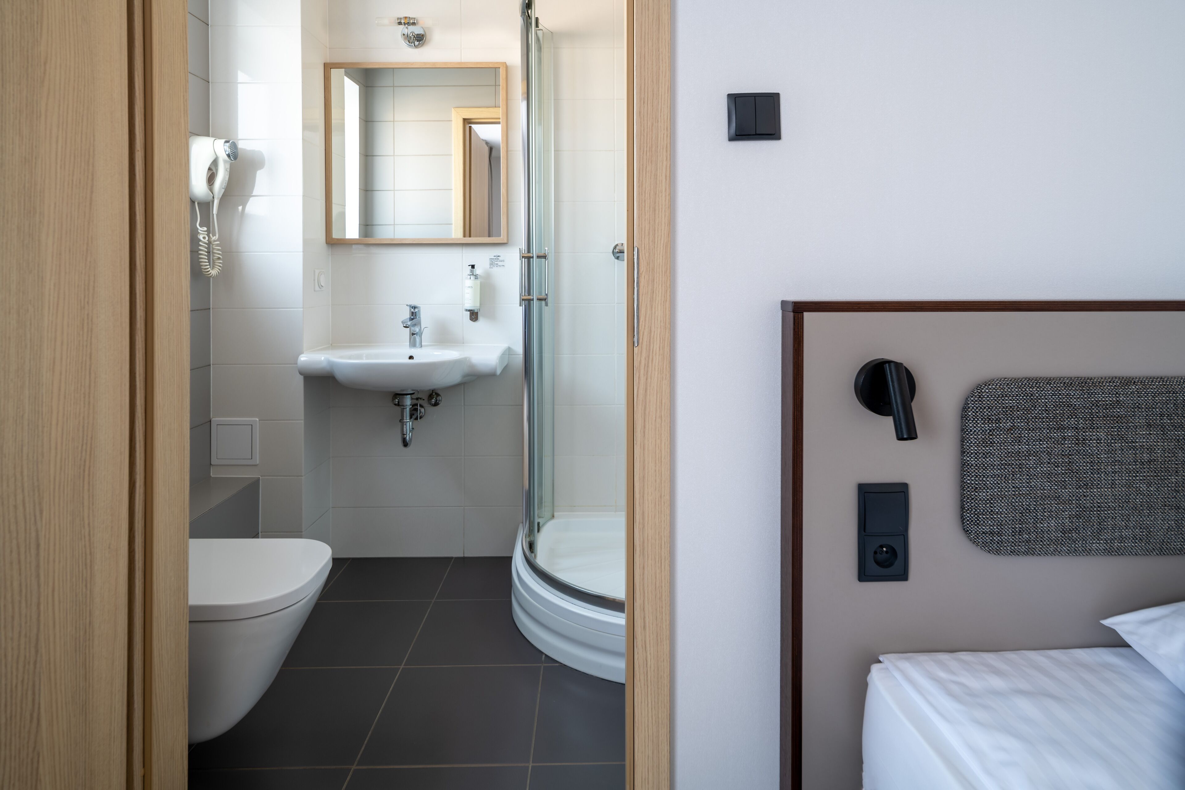 A modern bathroom with a toilet, sink, and shower.