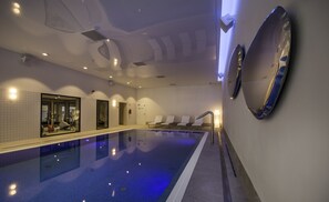 Una piscina techada, sillones reclinables de piscina