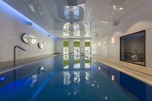 Una piscina techada, sillones reclinables de piscina