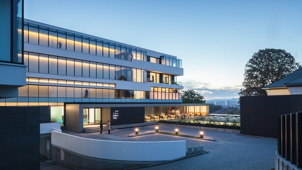 Een modern hotel met een meerlaagse structuur, een buitenzitgedeelte en een aangelegde binnentuin.