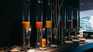 A bar area with multiple juice dispensers and a variety of food containers.