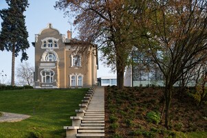 Un edificio grande e histórico con una imponente escalera que conduce a la entrada.