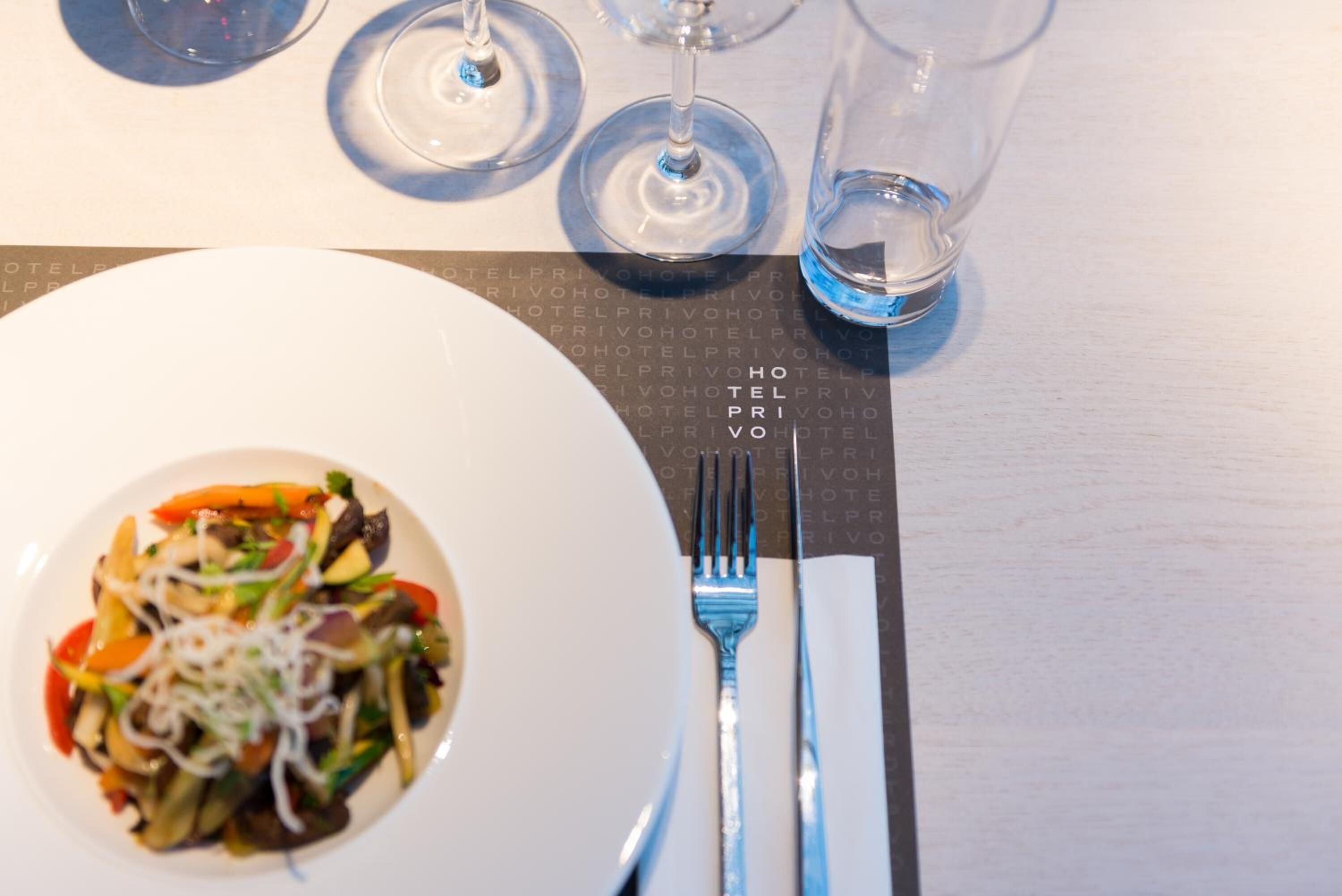Una mesa de comedor con un plato de comida, un tenedor y una servilleta.