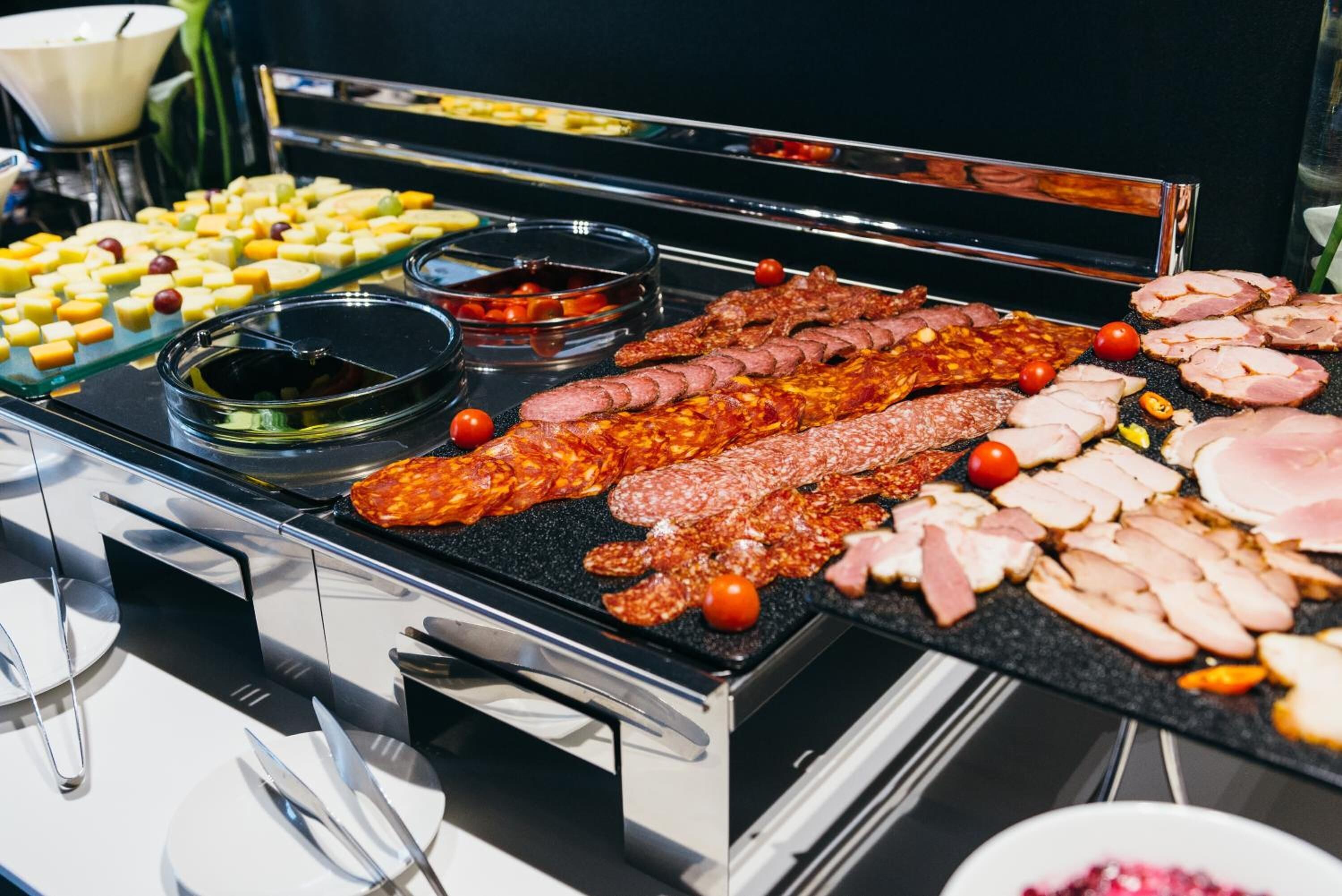 Een buffet met verschillende vleessoorten en kazen.