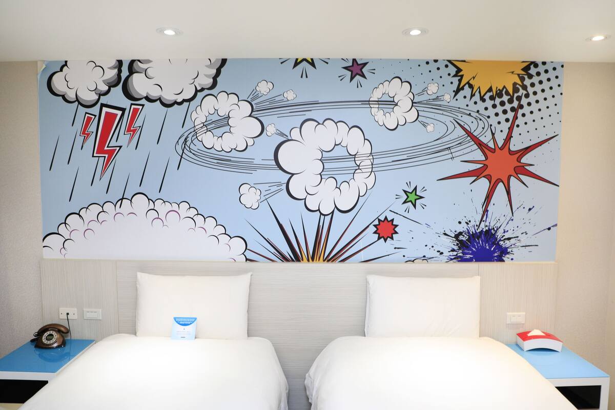 A hotel room with a bed, two bedside tables, and a wall mural depicting a stormy sky with clouds and lightning.