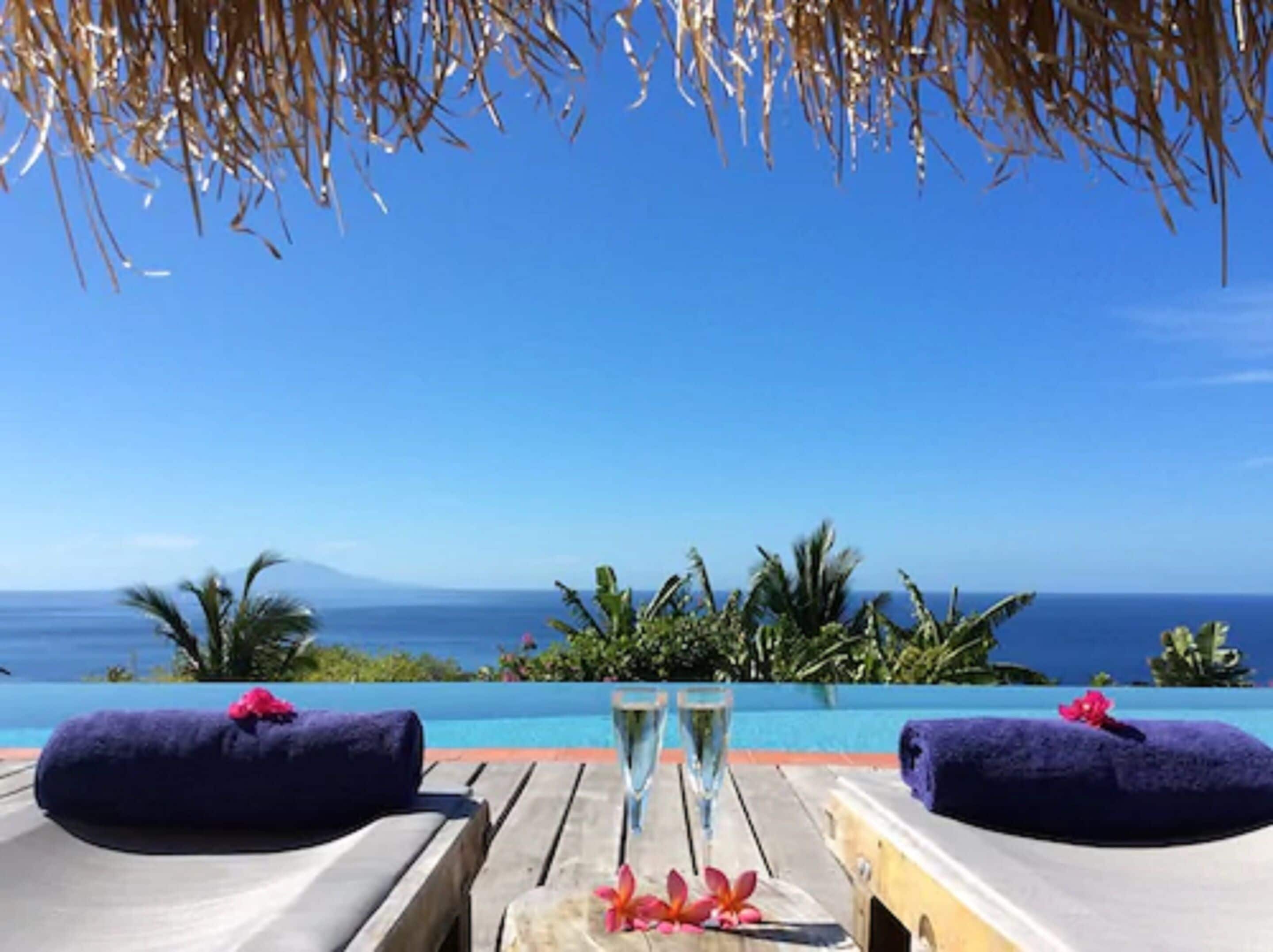 Una piscina al aire libre, sombrillas, tumbonas