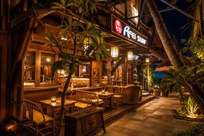An outdoor restaurant with wooden furniture and a sign that reads 'Aei Surf'. - 墾丁阿飛衝浪旅店 Afei Surf Inn - 步行南灣五分鐘 5 Min Walk from South Beach (Hengchun)