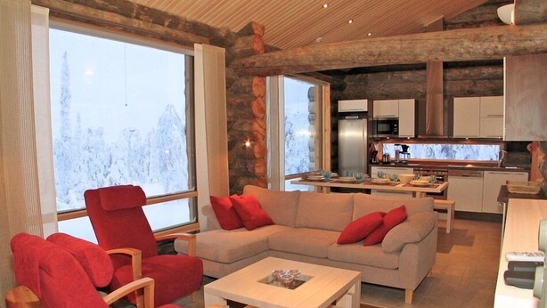 Un salon moderne avec une grande fenêtre, un canapé, un fauteuil rouge et une table basse.
