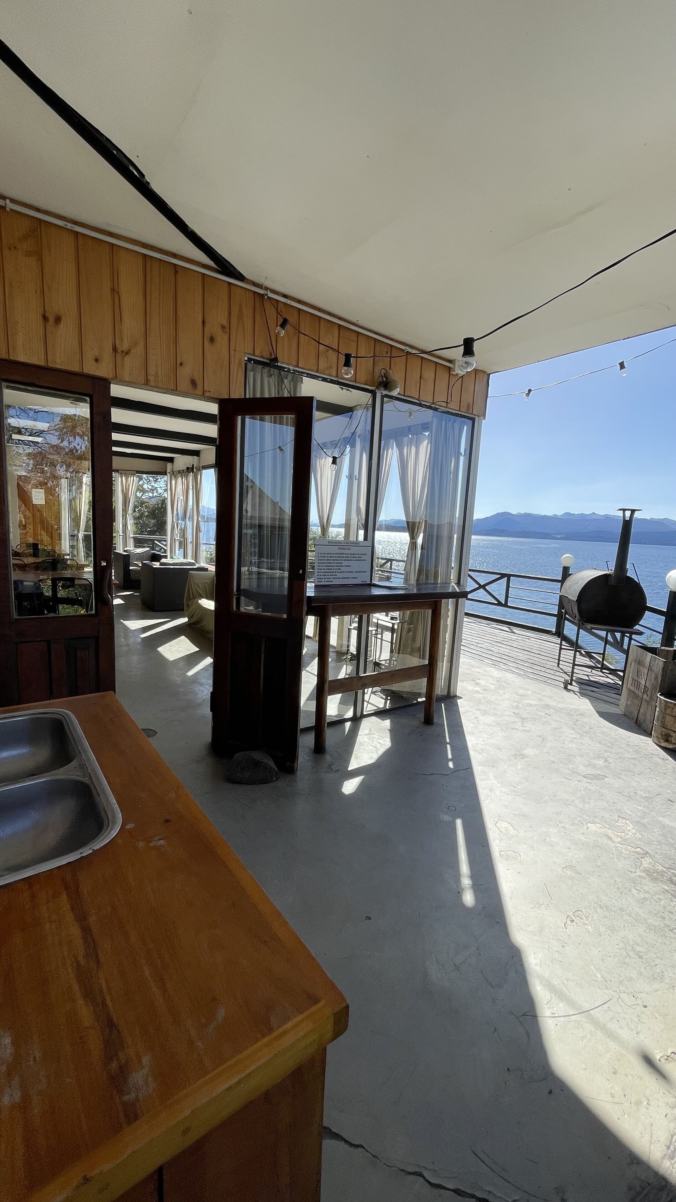 A wooden interior with a bar area, a grill, and a view of the water.